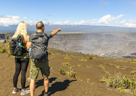 The Hiking couple seeing volcano national park from crater on the caldera Halemaumau around Hawaiʻi volcanoes national park